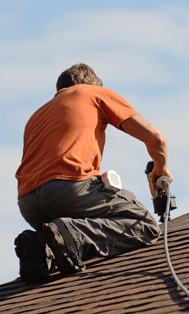 Contractor using air nailers while working on a roof